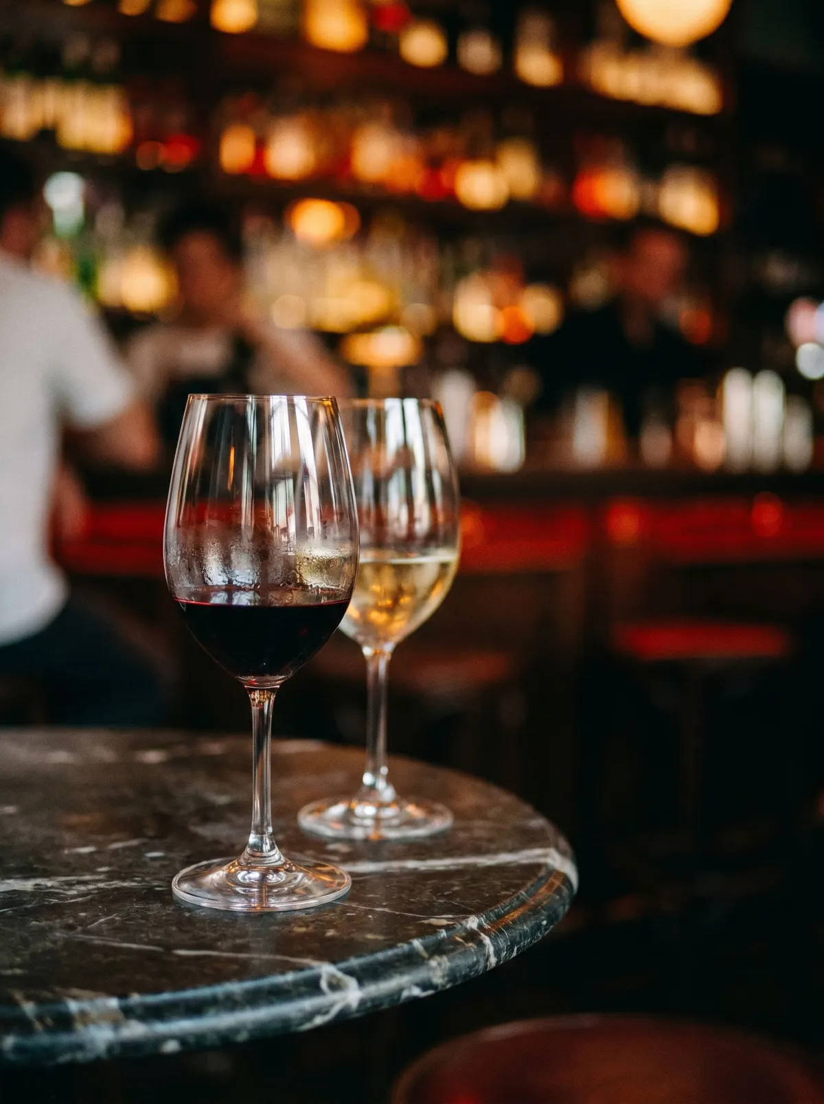 Warm bokeh and wine glasses, dim restaurant
